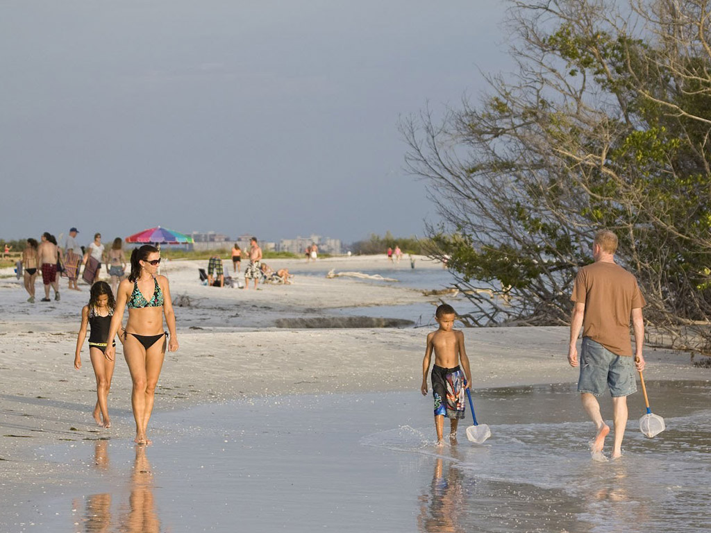 People walking on beach near sunset